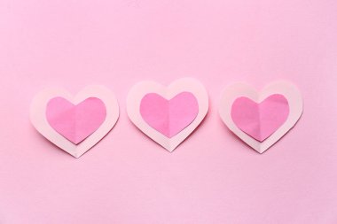 Paper hearts on pink background. Valentine's Day celebration