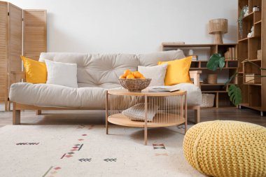 Oturma odasının içinde kanepe, raf ve portakallar var.