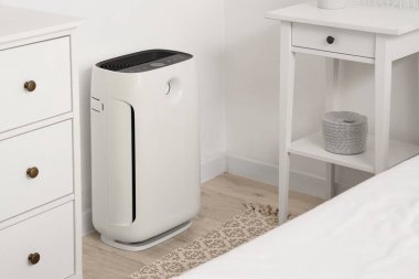 Yatak odasındaki ışık duvarının yanında hava temizleyici var.