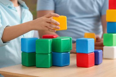 Baba ve küçük oğlu evde renkli küplerle oynuyorlar, yakın plan.