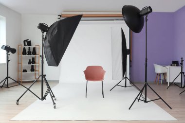 Profesyonel ekipman, sandalye ve beyaz arkaplan ile fotoğraf stüdyosunun içi