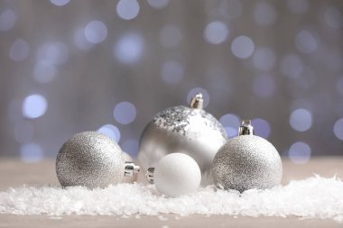 Bulanık ışıklara karşı masada karlı Noel topları