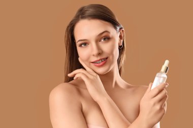 Diş telleri ve bej arka planda serumu olan genç bir kadın, yakın plan.