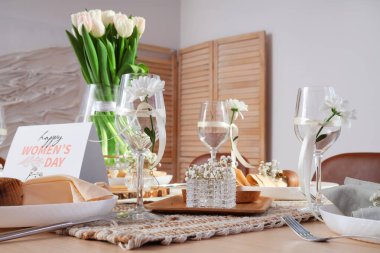 Uluslararası Kadınlar Günü kutlamaları için laleli şık masası ve tebrik kartı.