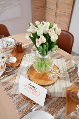 Uluslararası Kadınlar Günü kutlamaları için laleli ve tebrik kartlı güzel bir masa.