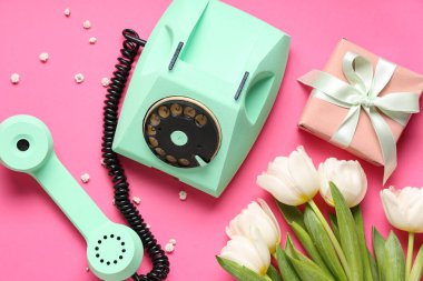 Retro telefon, güzel laleler ve pembe arka planda hediye kutusu. Uluslararası Kadınlar Günü