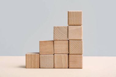 Gri arkaplanda tahta küplerden yapılmış merdiven