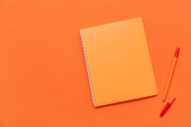 Defter ve kalem turuncu zemin üzerine