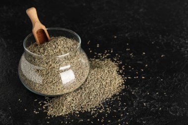 Siyah grunge arka planında kepçeyle kurutulmuş anason tohumları.