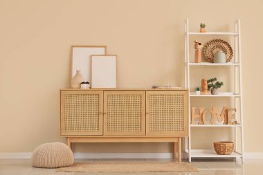 Ahşap tuvaletli, raf üniteli ve çerçeveli oturma odasının içi.