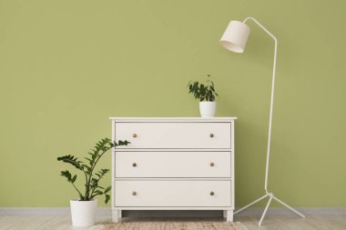 Beyaz klozet, lamba ve bitkilerle dolu bir oda.