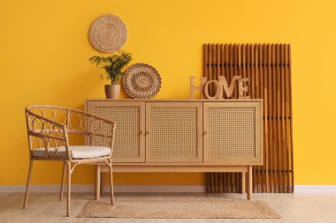 Odanın içinde ahşap klozet, koltuk ve katlanır ekran var.