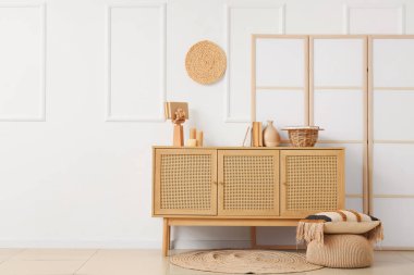 Odanın içinde ahşap klozet, puf ve katlanır ekran var.