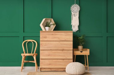 Odanın içinde ahşap tuvalet, sandalye ve masa var.