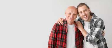 Oğlu gri arka planda yaşlı bir adam ve mesaj için yeri var.