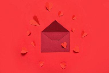 Zarflı kompozisyon ve kırmızı arka planda kağıt kalpler. Sevgililer Günü kutlaması