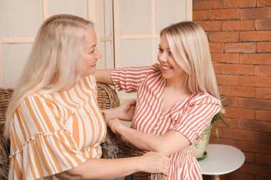 Güzel genç bir kadın ve annesi evde birlikte vakit geçiriyorlar.