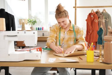 Stüdyoda kadın moda tasarımcısı çizim kalıbı