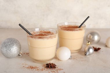 Yıldız anasonlu lezzetli eggnog kokteyli ve beyaz arka planda Noel topları.