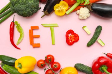 DETOX sözcüğü ve pembe arka planda taze sebzeli kompozisyon