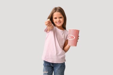 Beyaz arka planda patlamış mısırı olan mutlu küçük kız.