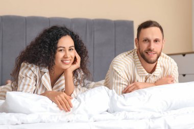 Yatak odasında pijamalı güzel bir çift yatıyor. Dünya Uyku Günü