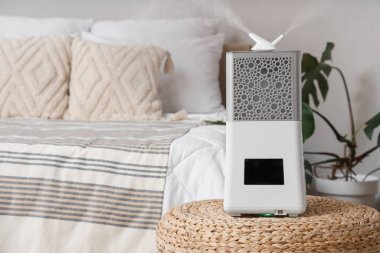 Yatak odasının yanındaki hasır sedirde modern nemlendirici.