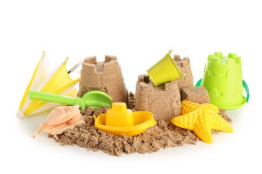 Beyaz arka planda kumdan kale, plaj oyuncakları ve küçük şemsiye