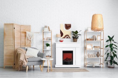 Modern oturma odasının içinde şöminesi, rafları ve koltuğu var.