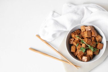 Beyaz arka planda kızarmış tofu peyniri ve mikro yeşil tabakla.