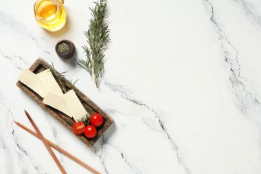 Tofu peyniri, domates ve çubuk dilimli tepsi mermer arka planda.