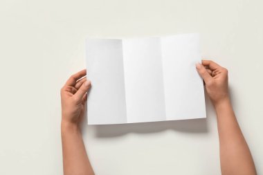 Beyaz arka planda boş broşürlü kadın elleri