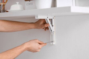 Erkek marangoz tornavidayla vidayı sıkıyor.