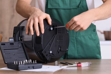 Erkek teknisyen vidayı tornavidayla sıkıyor.