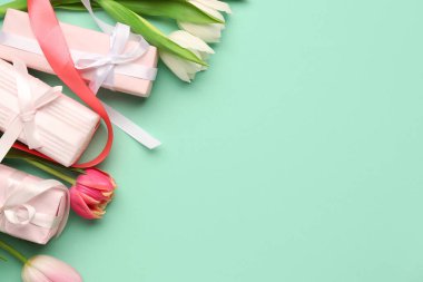 Turkuaz zemin üzerinde laleler olan hediye kutuları. Mutlu Kadınlar Günü