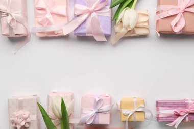 Beyaz arka planda laleleri olan hediye kutularından yapılmış çerçeve. Mutlu Kadınlar Günü