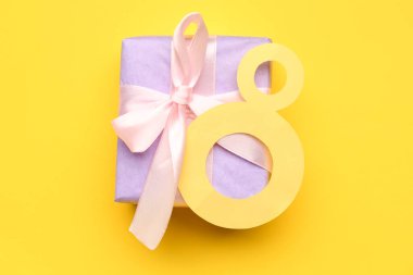 Sarı arka planda hediye kutusu olan kağıt figür 8. Mutlu Kadınlar Günü