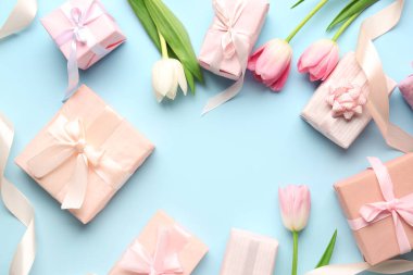 Mavi arka planda laleleri olan hediye kutularından yapılmış çerçeve. Mutlu Kadınlar Günü