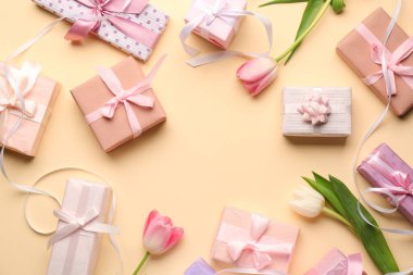 Bej arka planda laleleri olan hediye kutularından yapılmış çerçeve. Mutlu Kadınlar Günü