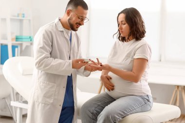 Klinikte glukometre kullanan hamile bir kadın. Gebelik Diyabet Konsepti