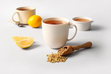 Limonlu sıcak karabuğday çayı ve gri arka planda bir kase bal