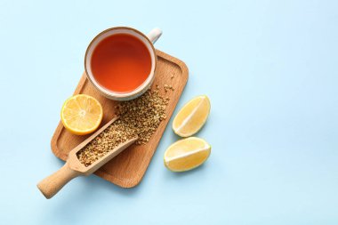 Mavi arka planda limonlu sıcak karabuğday çayı.