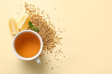 Sarı arka planda naneli ve limonlu sıcak karabuğday çayı.