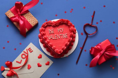 Hediye kutularıyla tatlı bento keki ve mavi arka planda bir zarf. Sevgililer Günü kutlaması