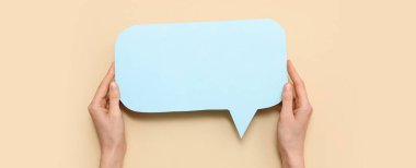 Bej arkaplanda boş konuşma baloncuğu olan eller