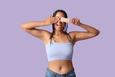 Leylak kaplamalı tatlı dondurmalı güzel bir Afro-Amerikalı kadın.