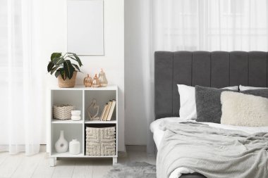 Yatak odasının içinde raf ünitesi ve dekoratif balkabakları var.