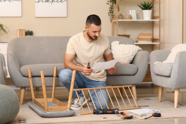 Evde manuel ve tornavida montajı yapan genç adam.