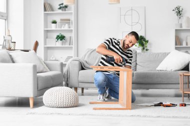 Evinde eğitim masası olan genç bir adam.