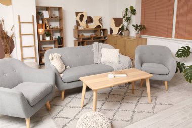 Gri kanepesi, koltuğu ve güzel tabloları olan şık bir oturma odası.